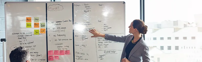 Frau erläutert Projektplan auf Kanban-Board